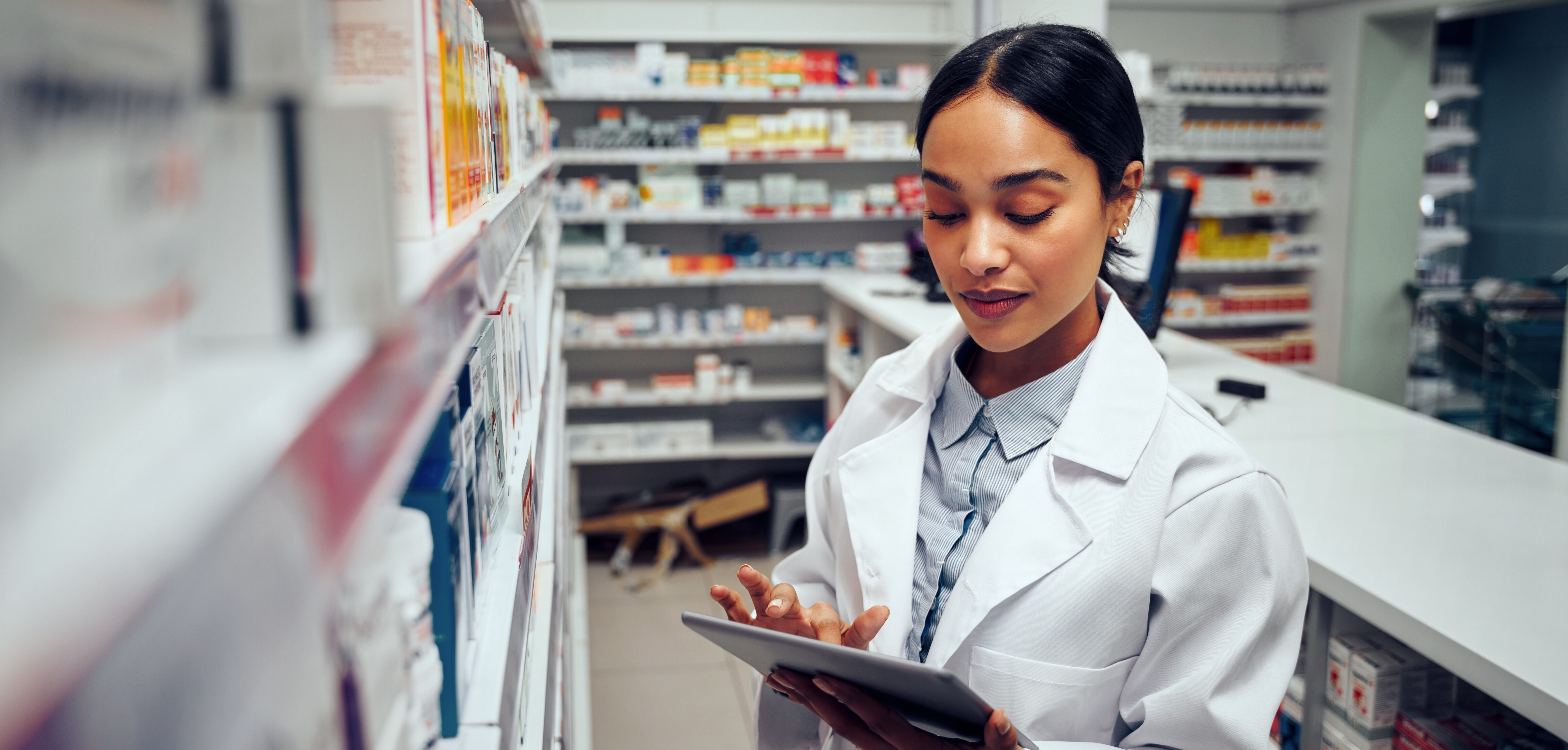 Young,Female,Pharmacist,Checking,Inventory,Of,Medicines,In,Pharmacy,Using